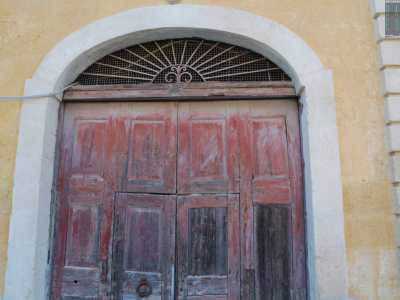 Ci avviciniamo all�entrata: un grande portone in legno inserito in un arco a tutto sesto ribassato...